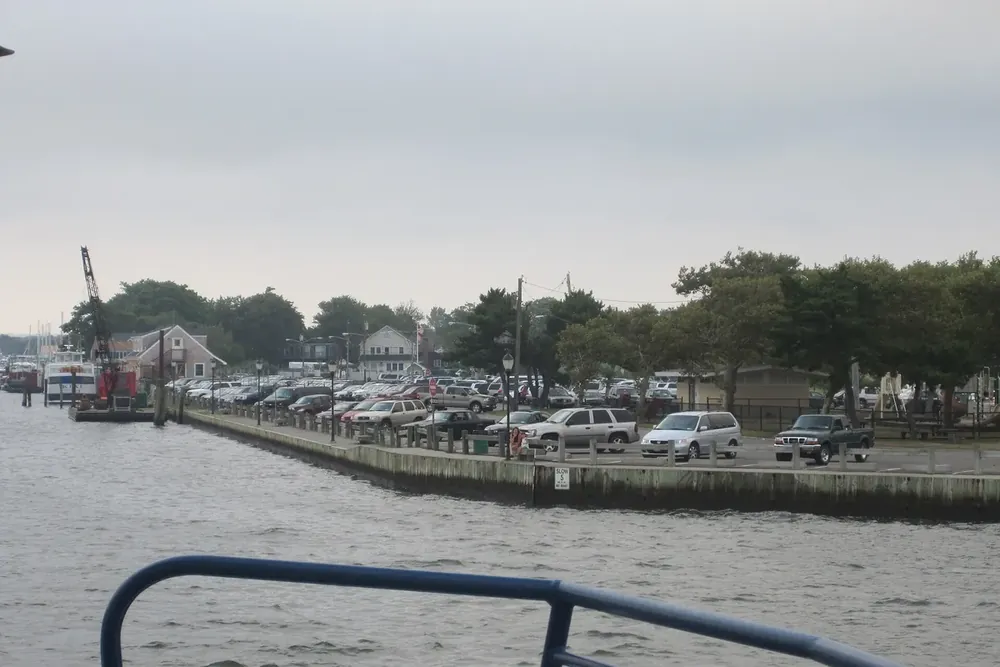 Waterfront parking area and bulkhead along the harbor seen from the water in Patchogue, New York